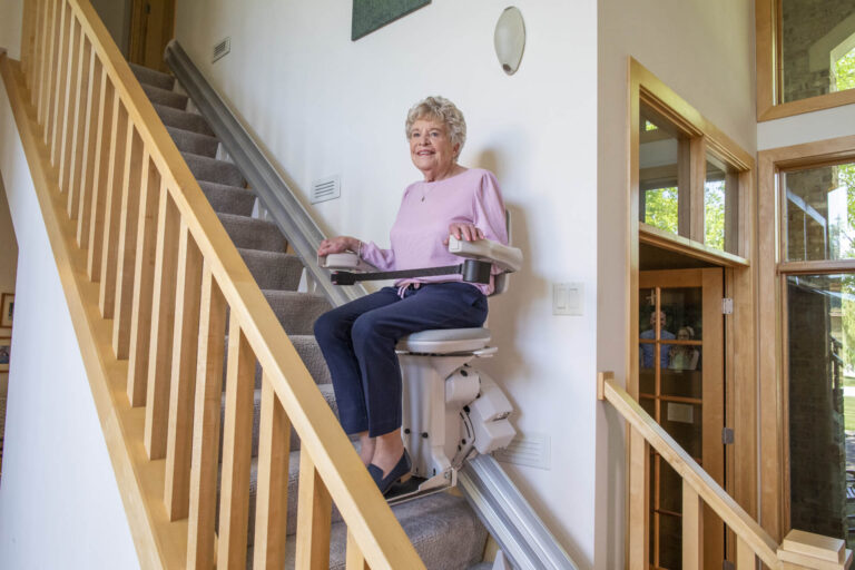 A woman uses a Bruno stair lift.
